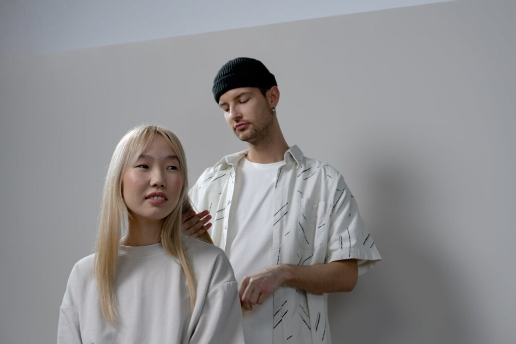 photo of a man in a white shirt styling a woman s hair