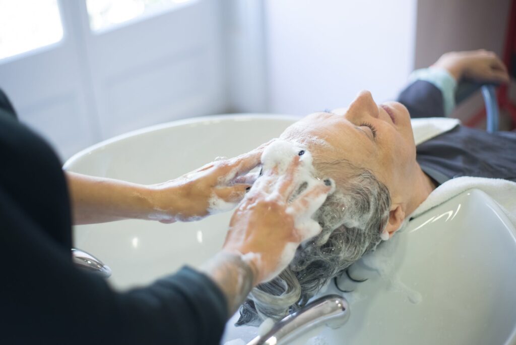 an elderly woman having her hair wash